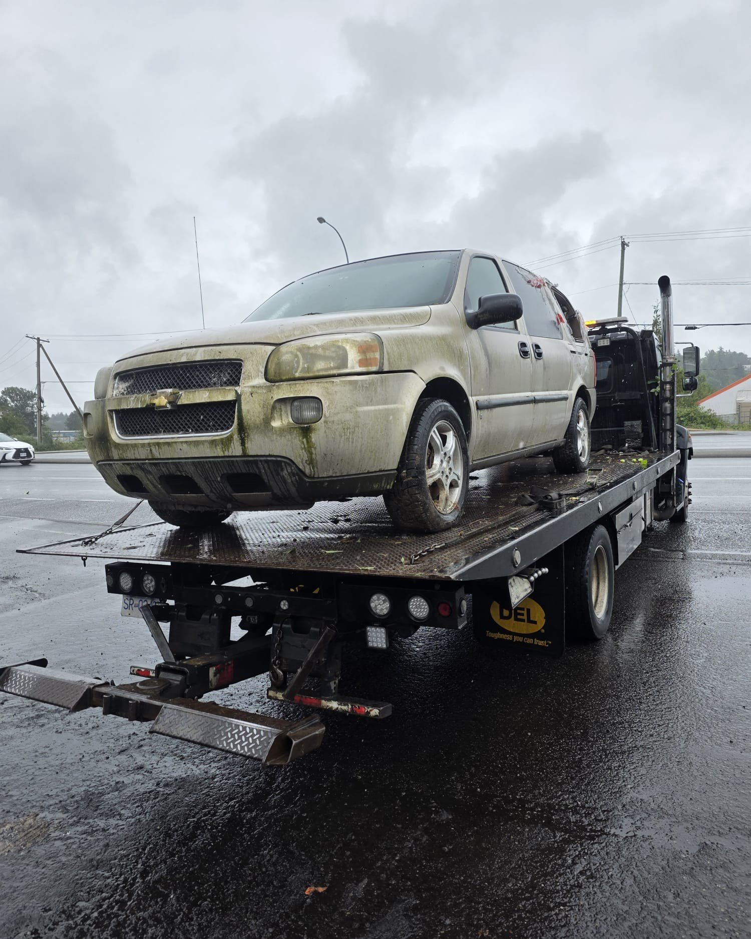 Flatbed tow truck removing a scrap car in Vancouver
