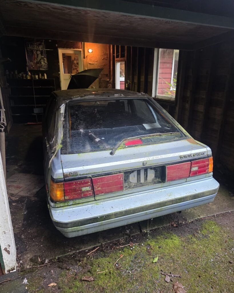 Older sedan parked in a covered residential space