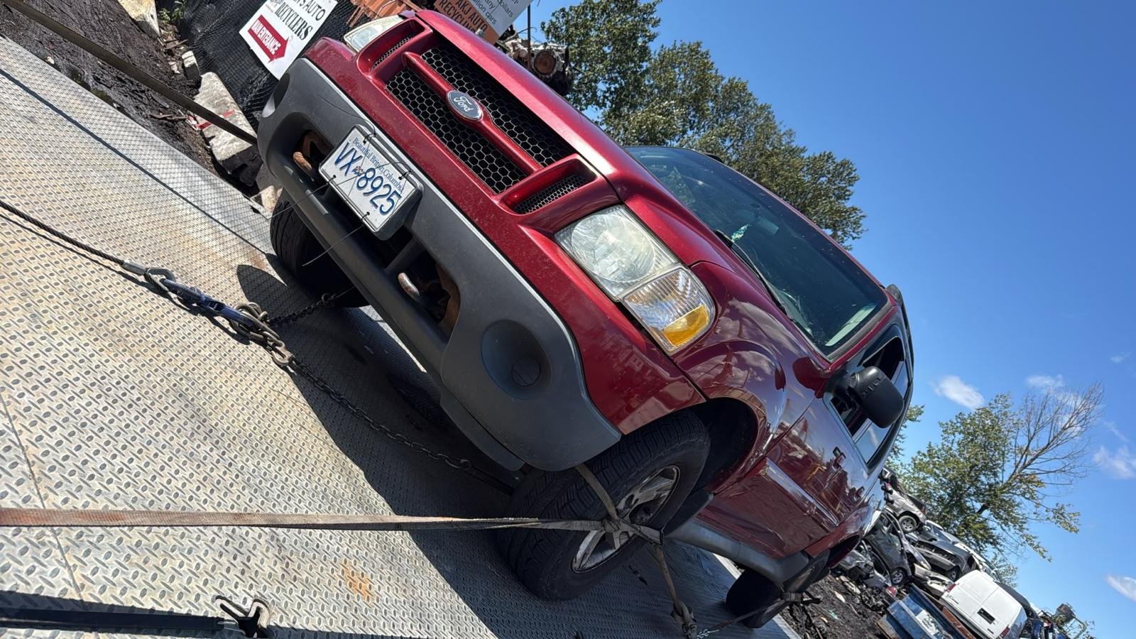 Red SUV secured on a flatbed truck