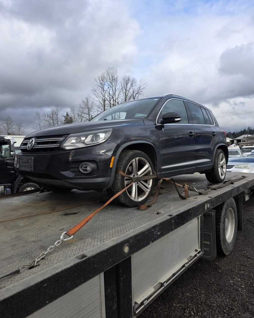 Dark SUV secured on a flatbed tow truck for vehicle removal in Vancouver