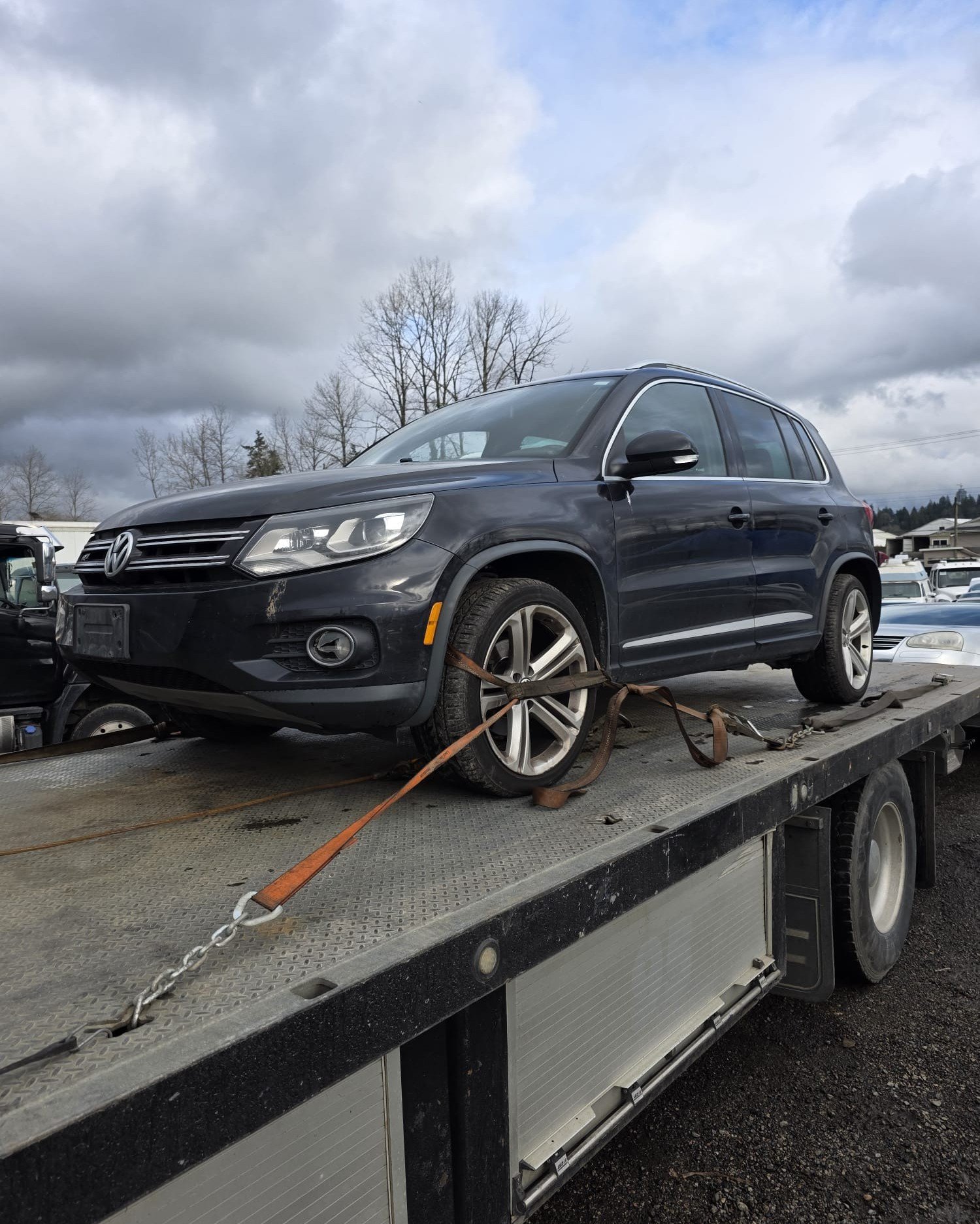 Dark SUV secured on a flatbed tow truck for vehicle removal in Vancouver